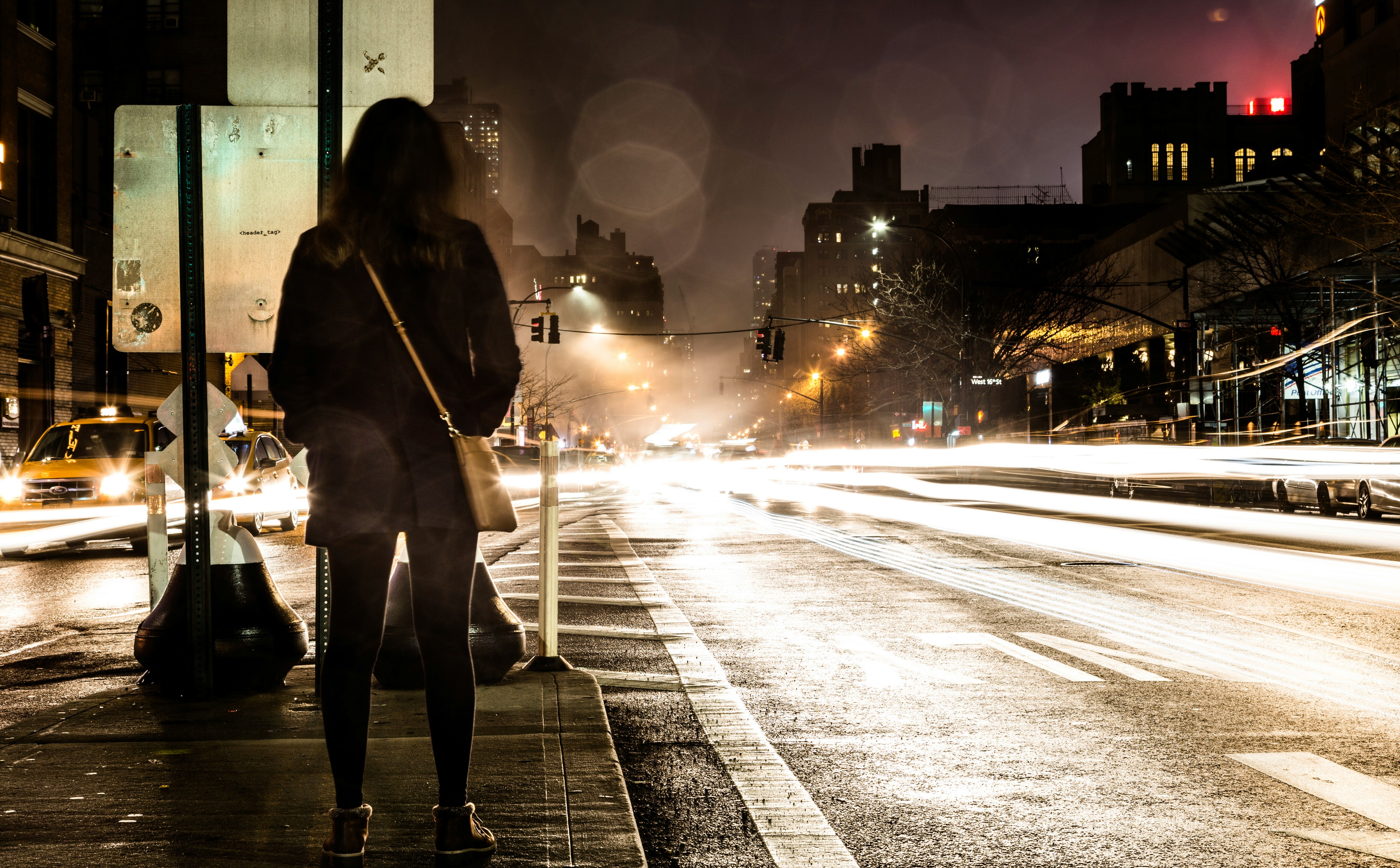 timelapse photography of woman standing near road